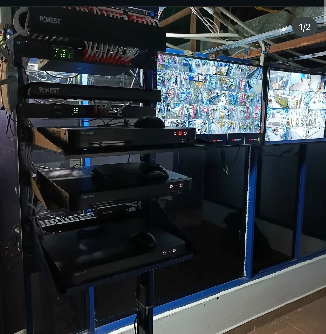 Rack de grabadores Hikvision y Powest con pantallas de monitoreo CCTV
